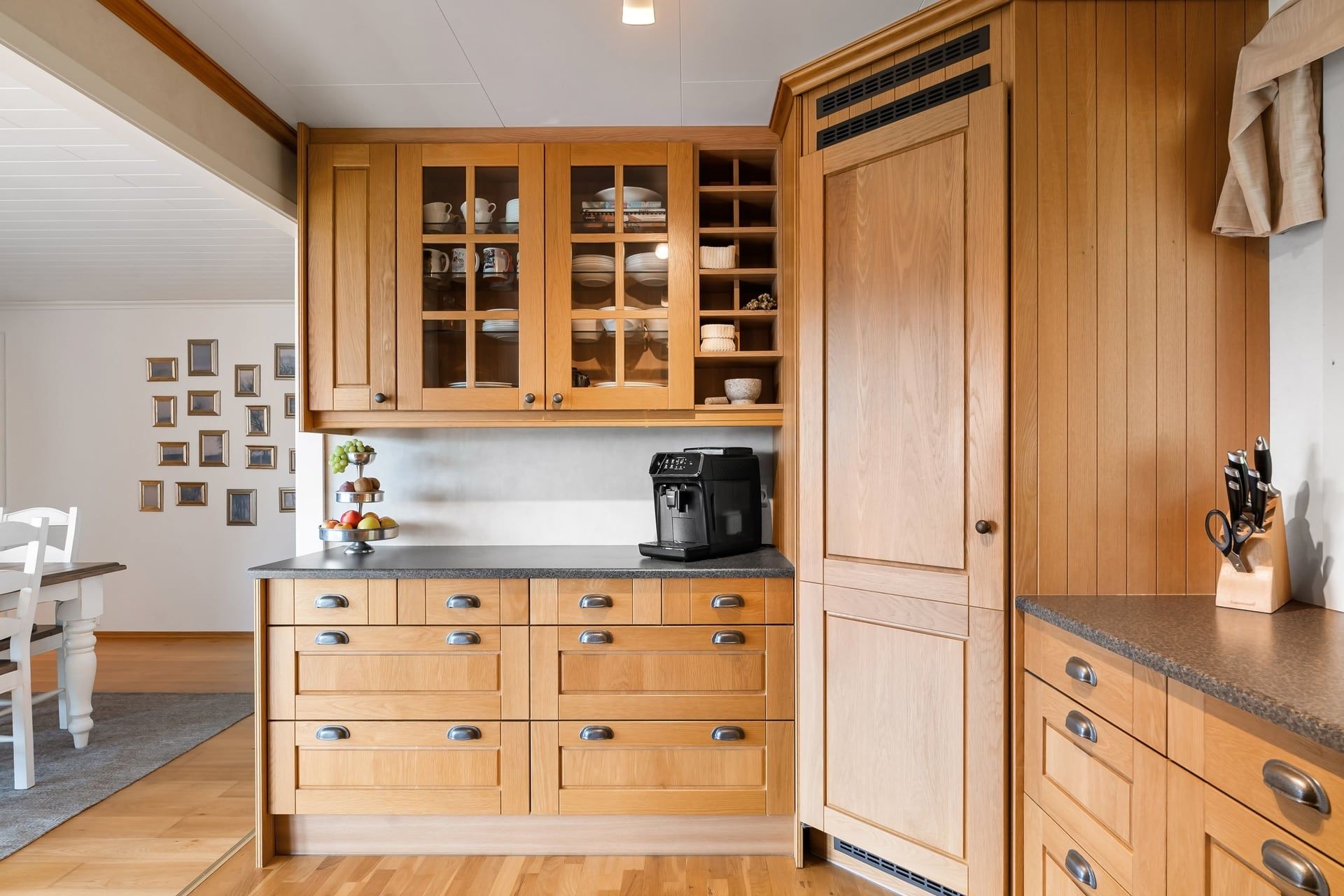 Keuken met eiken kasten, vitrinedeuren en een stenen werkblad